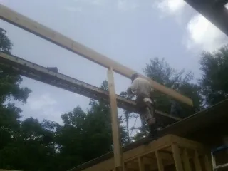 Carpenter setting a ridge beam over a new addition frame — Ice Dam Removal by Roofing Brothers in Fredonia